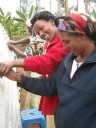 women laughing, working on greenhouse