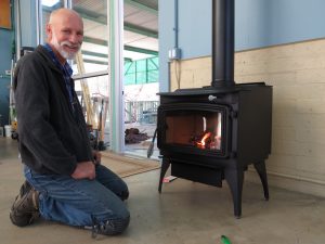 David Omick installing a wood burning stove, photo by Kai Staats