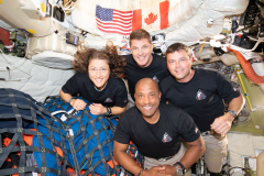 art002e013361 (April 7, 2026) – The Artemis II crew – (clockwise from left) Mission Specialist Christina Koch, Mission Specialist Jeremy Hansen, Commander Reid Wiseman, and Pilot Victor Glover – pause for a group photo inside the Orion spacecraft on their way home. Following a swing around the far side of the Moon on April 6, 2026, the crew exited the lunar sphere of influence (the point at which the Moon's gravity has a stronger pull on Orion than the Earth's) on April 7, and are headed back to Earth for a splashdown in the Pacific Ocean on April 10.